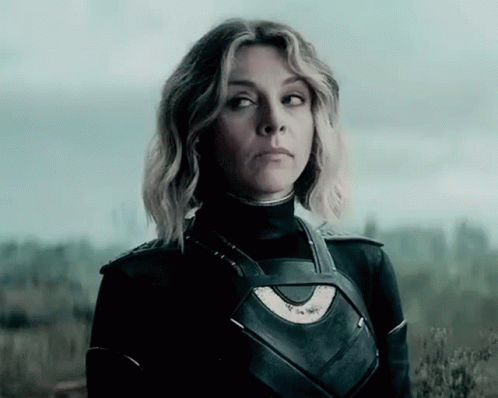 A Woman In A Superhero Costume Is Standing In A Field . GIF