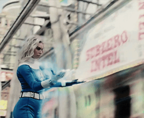 a woman in a superhero costume is standing in front of a sign that says ferrero