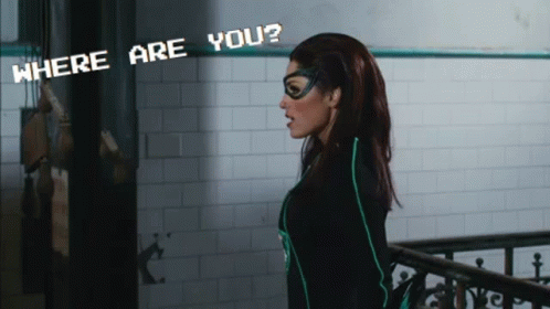 A Woman In A Superhero Costume Stands In Front Of A Sign That Says " Where Are You " GIF