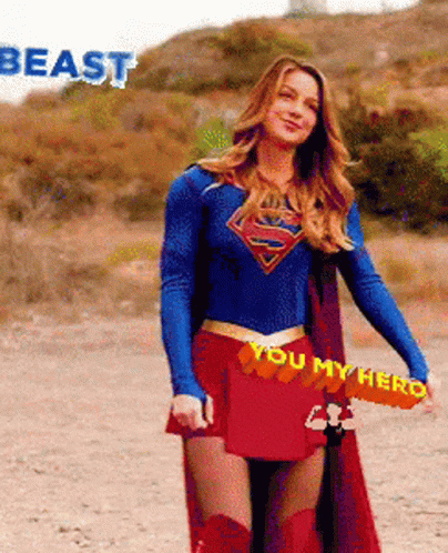 A Woman In A Superman Costume Is Holding A Sword That Says You My Hero On It GIF