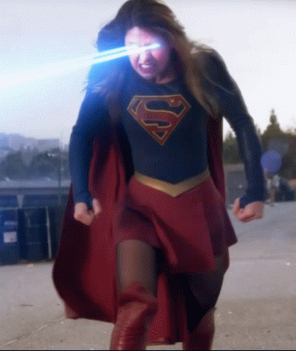A Woman In A Superman Costume With The Letter S On Her Shirt GIF