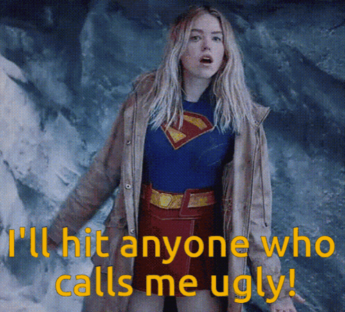 A Woman In A Superman Costume With The Words " I 'Ll Hit Anyone Who Calls Me Ugly " Below Her GIF