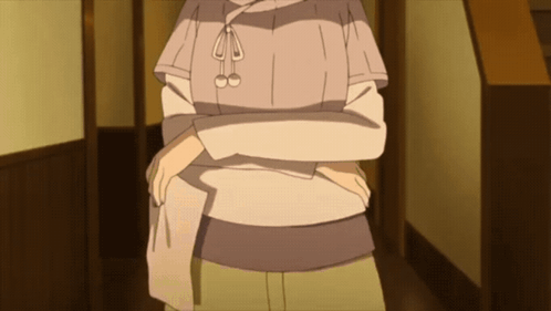 A Woman In A Sweater Is Standing In A Hallway GIF
