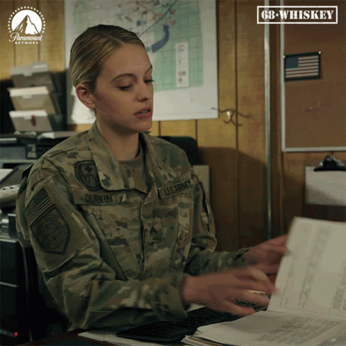 A Woman In A Us Army Uniform Sits At A Desk With Papers GIF