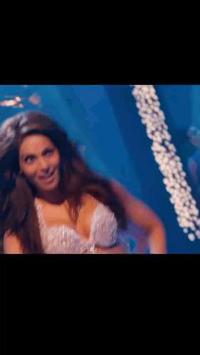 A Woman In A Very Revealing Top Is Dancing In A Dark Room GIF