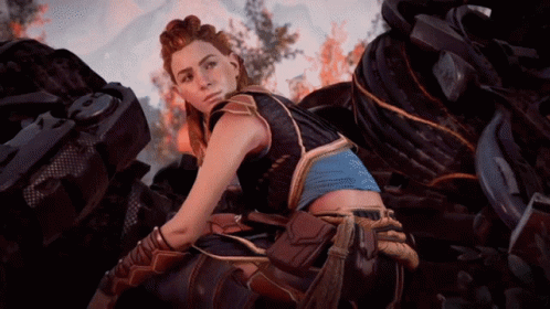 A Woman In A Video Game Is Sitting In Front Of A Pile Of Tires GIF