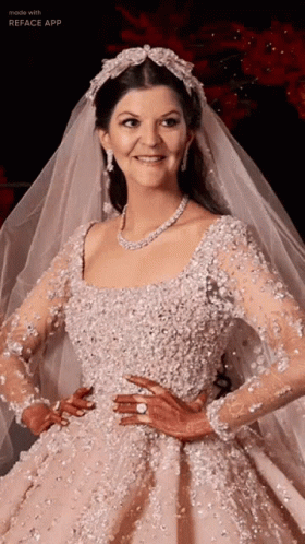 A Woman In A Wedding Dress And Veil Is Smiling GIF