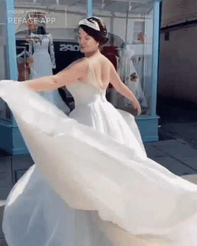A Woman In A Wedding Dress Is Dancing In Front Of A Store With The Number 280 On It GIF