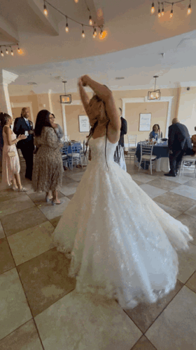 A Woman In A Wedding Dress Is Dancing With Her Arms In The Air GIF
