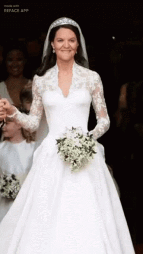 A Woman In A Wedding Dress Is Holding A Bouquet Of White Flowers GIF