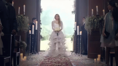 a woman in a wedding dress is walking down the aisle in a church