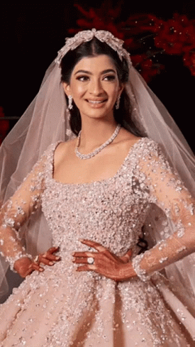 A Woman In A Wedding Dress With A Veil On Her Head Is Smiling GIF
