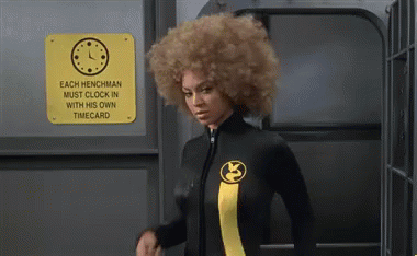 A Woman In A Wetsuit Is Standing In Front Of A Sign That Says Each Henchman Must Clock In With His Own Time Card GIF