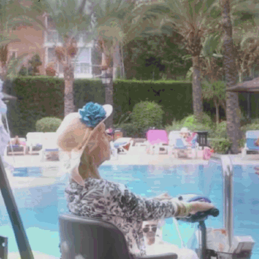 A Woman In A Wheelchair Sits By A Swimming Pool GIF