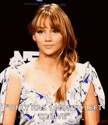 A Woman In A White And Blue Dress Is Standing In Front Of A Black Background . GIF