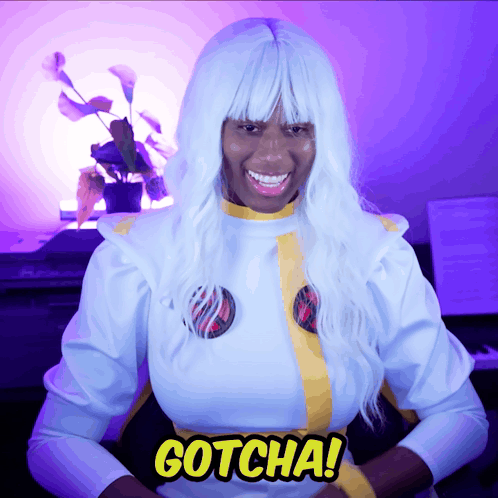 A Woman In A White Costume With The Word Gotcha On Her Chest GIF