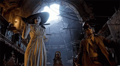 A Woman In A White Dress And A Man In A Trench Coat Are Standing In A Dark Room . GIF