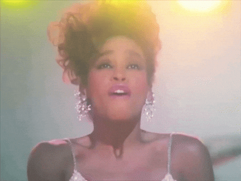 a woman in a white dress and earrings is singing