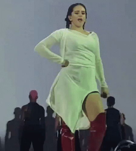 A Woman In A White Dress And Red Boots Is Dancing On Stage . GIF