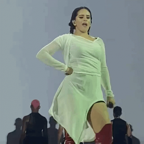 A Woman In A White Dress Holds A Microphone In Her Hand GIF