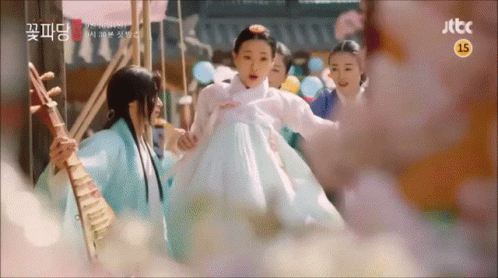 A Woman In A White Dress Is Being Held By A Man Playing A Musical Instrument .. GIF