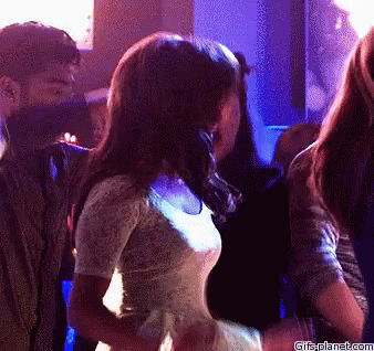 A Woman In A White Dress Is Dancing In A Club With Gifsplanet.com Written On The Bottom Of The Image GIF