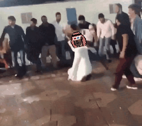 A Woman In A White Dress Is Dancing In A Crowd Of People GIF