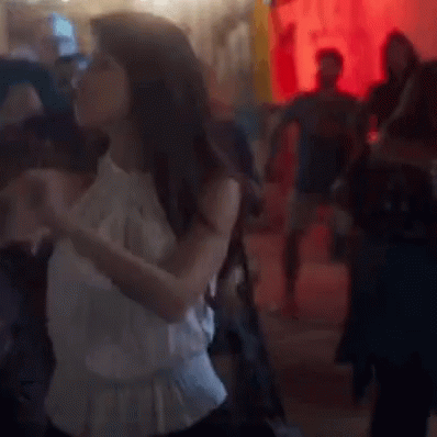 Woman In White Dress Dancing On Crowded Floor GIF