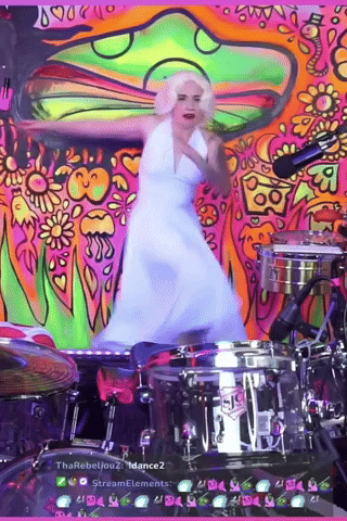 A Woman In A White Dress Is Dancing In Front Of A Drum Set That Says Sis On It GIF