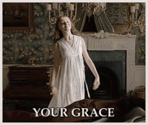 A Woman In A White Dress Is Dancing In Front Of A Fireplace With The Words " Your Grace " Written Below Her GIF