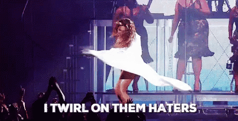 A Woman In A White Dress Is Dancing On A Stage With The Words I Twirl On Them Haters Written Below Her GIF