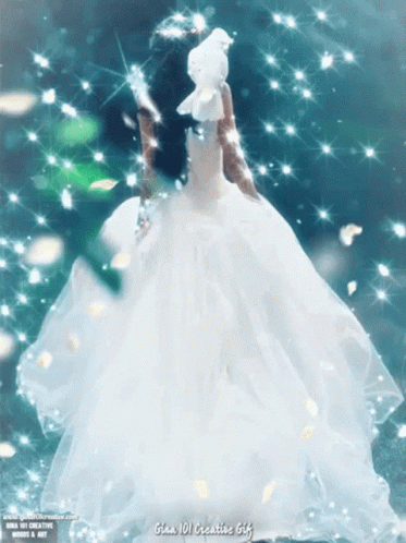 A Woman In A White Dress Is Holding A White Dove In Her Hand GIF