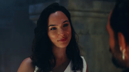 A Woman In A White Dress Is Smiling At A Man GIF