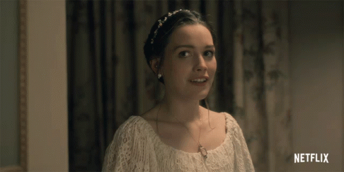 A Woman In A White Dress Is Smiling With A Netflix Logo In The Corner GIF