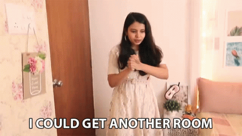 A Woman In A White Dress Is Standing In A Room With The Words " I Could Get Another Room " Above Her GIF