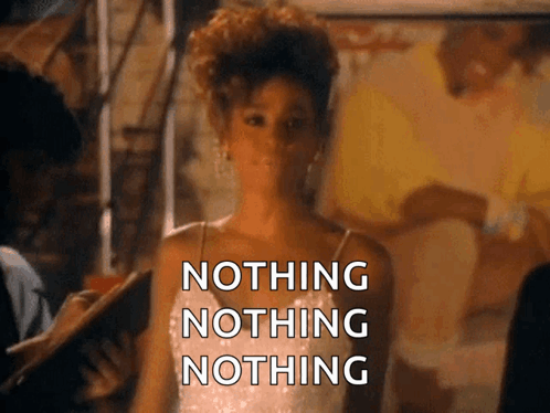A Woman In A White Dress Is Standing In Front Of A Sign That Says " Nothing Nothing Nothing " GIF
