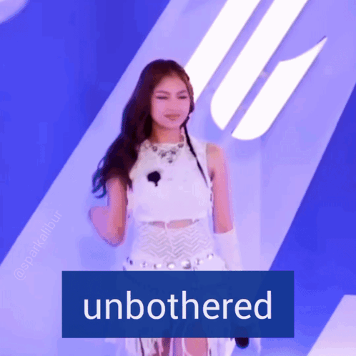 A Woman In A White Dress Is Standing In Front Of A Sign That Says " Unbothered " GIF