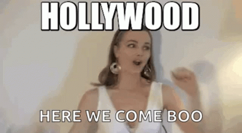 a woman in a white dress is standing in front of a wall with a meme .