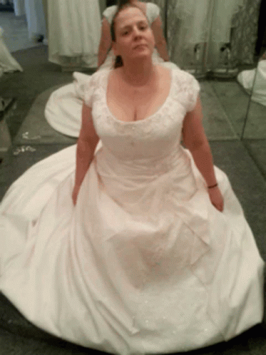 A Woman In A White Dress Sits On The Floor GIF