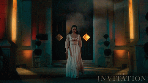 A Woman In A White Dress Stands In Front Of A Building With The Invitation Written On It GIF