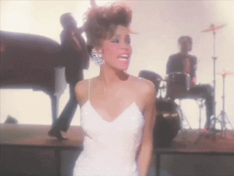 a woman in a white dress stands on a stage