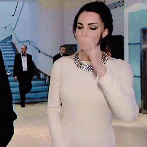 A Woman In A White Dress With A Necklace Around Her Neck GIF