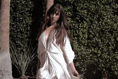 a woman in a white dress with a plunging neckline