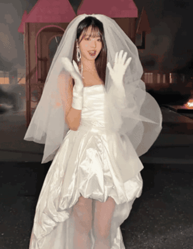 A Woman In A White Dress With A Veil On Her Head GIF