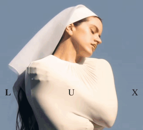 A Woman In A White Dress With The Letters L U And X On Her Chest GIF