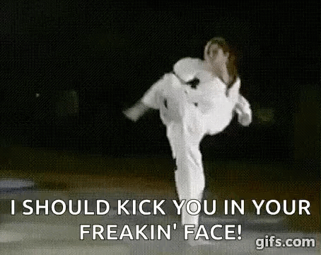 A Woman In A White Karate Uniform Is Kicking A Man In The Face . GIF