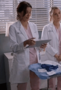 A Woman In A White Lab Coat Holds A Tablet GIF