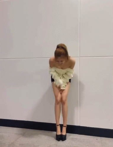 A Woman In A White Off The Shoulder Top And Shorts Is Dancing . GIF