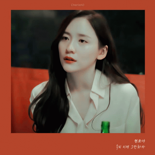 A Woman In A White Shirt Holds A Green Bottle In Her Hand GIF
