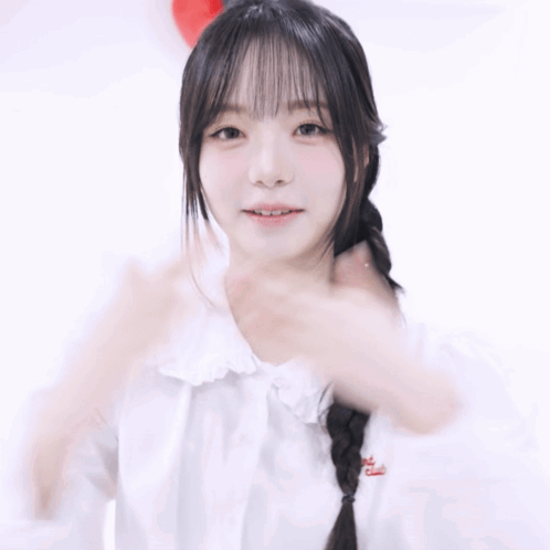 A Woman In A White Shirt Holds Her Hands To Her Chest GIF